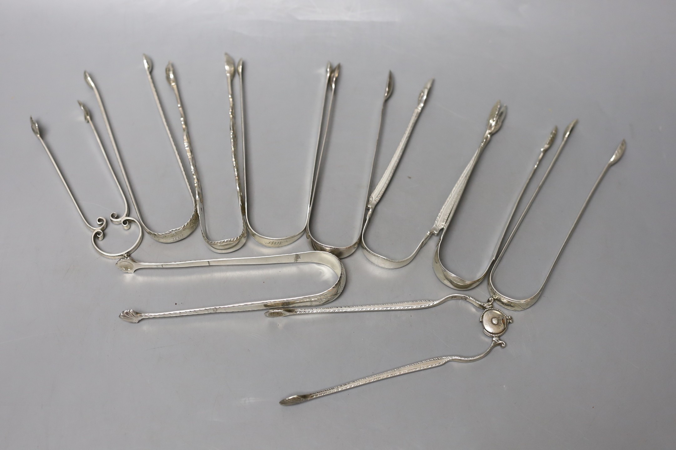 Ten assorted late 18th/early 19th century pairs of silver sugar tongs, various patterns, dates and makers, including two fire tong design, one hallmarked for Newcastle, 10.5oz.